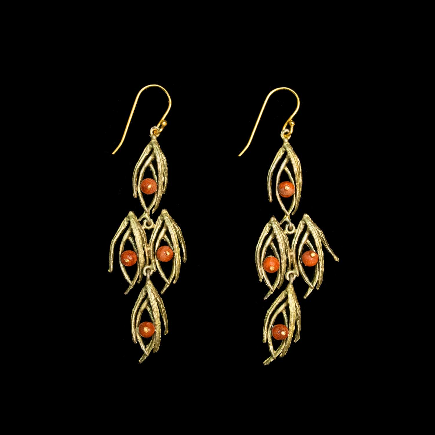 A pair of green-toned dangle earrings with leaf-like textured metalwork and three small round orange-red beads on each earring, shown against a solid black background.