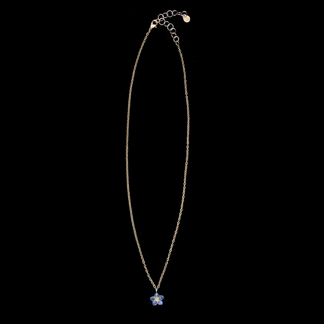 Necklace with a blue flower pendant on a black background