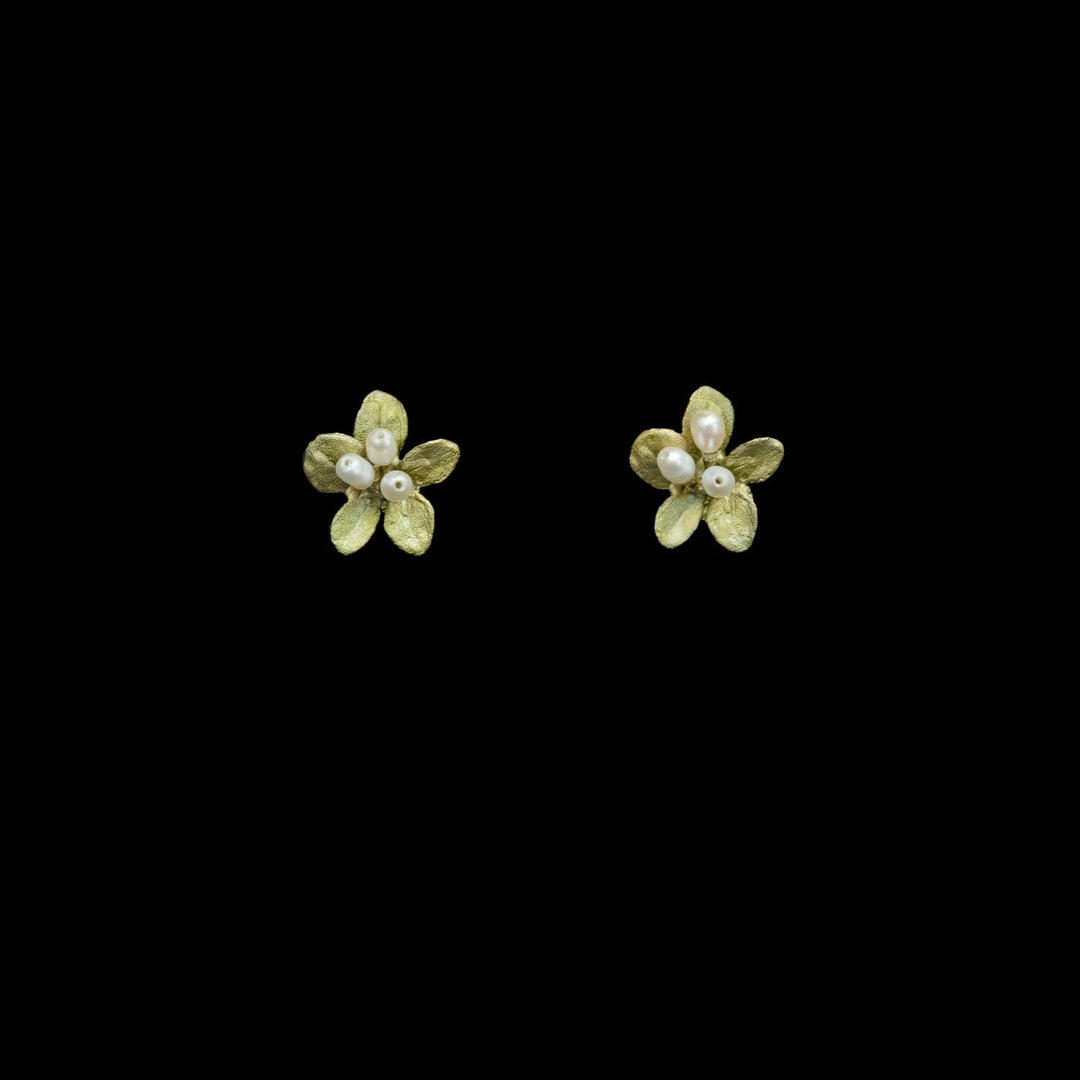 A pair of small flower-shaped stud earrings in textured green with white pearl centers, shown on a solid black background.