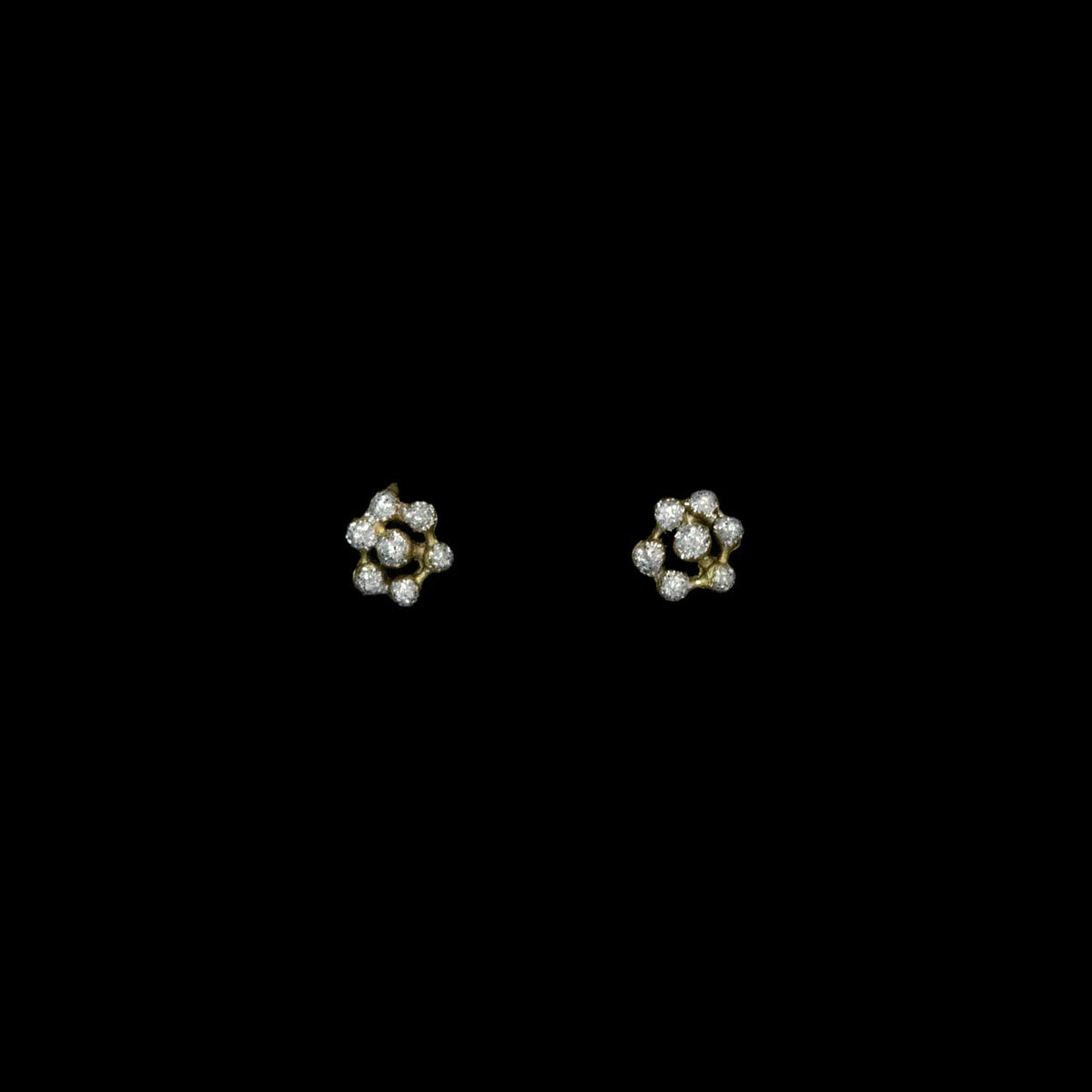 Pair of floral earrings with crystal dust dots on a black background