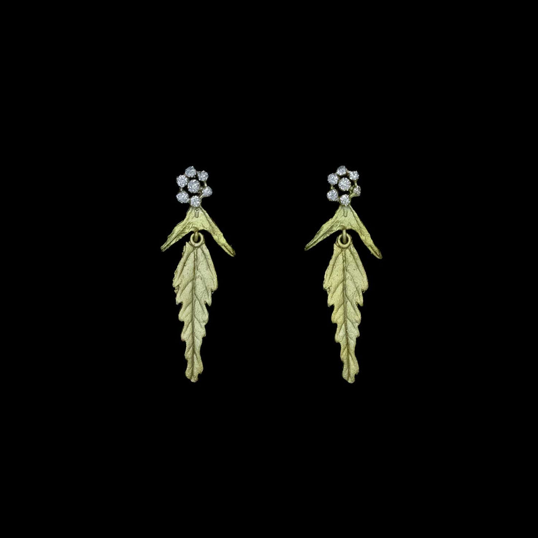 Pair of leaf-shaped earrings with crystal dust clusters at the top on a black background