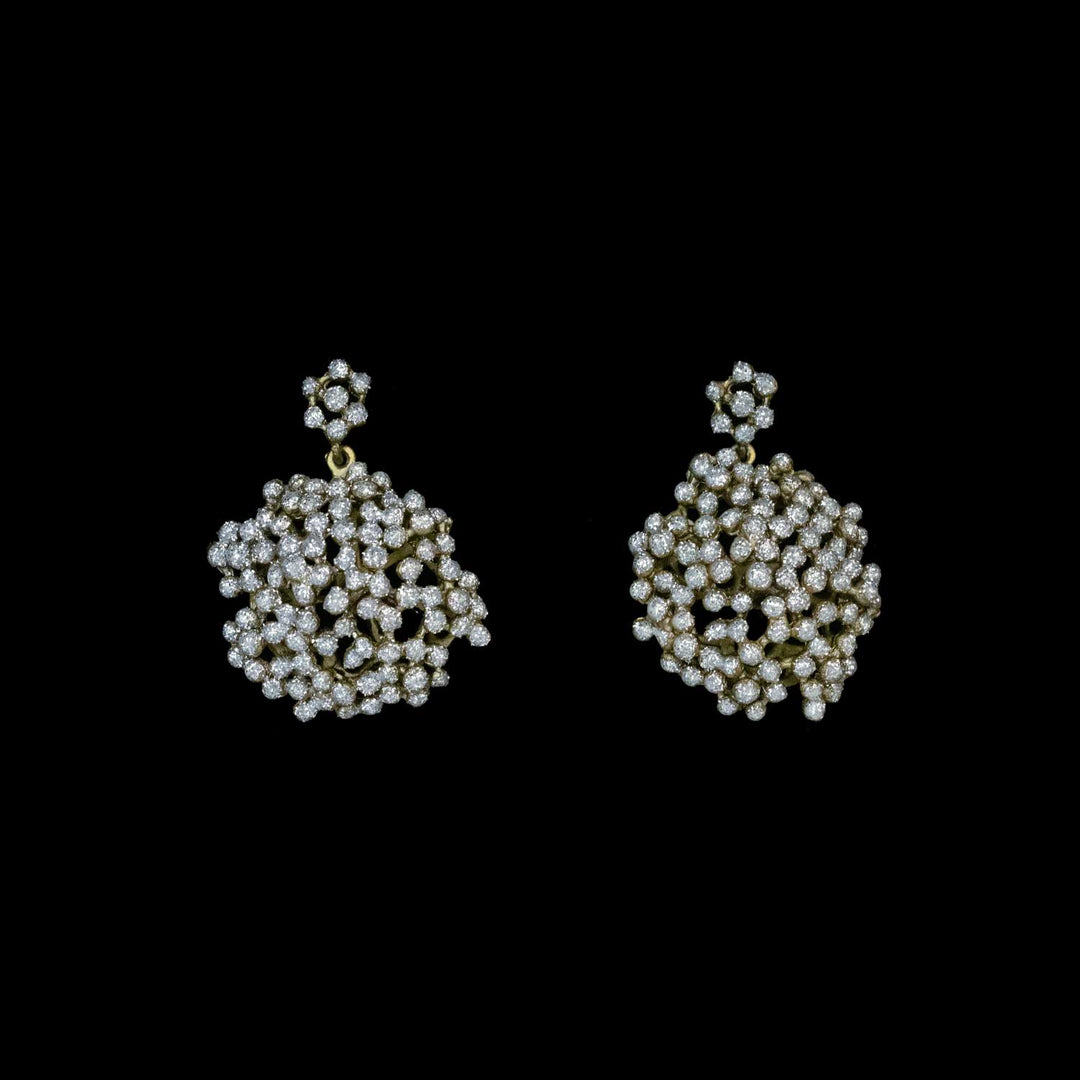 Pair of round lace-like crystal dust earrings on a black background